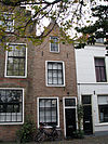 Huis met gecementeerde topgevel. Twee kogels ingemetseld