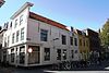 Huis met rechte gepleisterde gevel. Dakkapel. Op de hoek met Kerkstraat 1: moderne winkelpui. Kelderlichten
