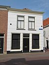 Woonhuis met gepleisterde lijstgevel onder Mansardekap
