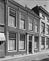 Lijstgevel. Huis van parterre en verdieping. Deuromlijsting met verdiepte pilasters, gesneden deur en consoles onder de kroonlijst Lod. XIV