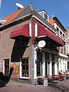 Hoekpand met schilddak en lijstgevel met gemetselde muurdammen tussen de verdiepingsvensters