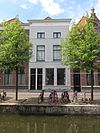 Pand met gepleisterde lijstgevel met lage bovenverdieping