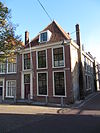 Hoekpand Breestraat onder schilddak. Voor en achtergevels onder rechte lijsten; IJsselstenen zij- en achtergevels. Deur met eenvoudige pilasteromlijsting en bovenlicht; Empireramen. Stoep met stoeppalen