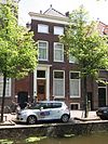 Pand met gevel, van lage bovenverdieping en rechte lijst voorzien. Deuromlijsting met verdiepte pilasters en gesneden Lod. XIV- consoles. Stoep met hardstenen palen en hek