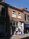 Pand met gesausde gevel onder lijst en deuromlijsting met pilasters