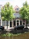 Pand onder hoog schilddak waarin deuromlijsting met pilasters en hoofdgestel