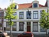 Pand eenvoudige deuromlijsting met pilasters en geprofileerde vensteromlijstingen