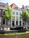 Pand onder hoog schilddak. Gepleisterde lijstgevel, waarin geprofileerde houten vensteromlijstingen. Stoep met mooie, gecanneleerde stoeppalen