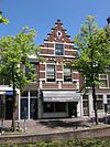 Pand met trapgevel versierd met natuurstenen banden, geprofileerde waterlijsten, geblokte ontlastingsbogen en in de top een cartouche-vormig blind oeil-de-boeuf