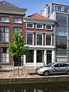 Pand met lijstgevel. De vensters van de benedenverdieping hebben geprofileerde houten omlijstingen; de verdiepingsvensters hoofdgestellen. Lage bovenverdieping