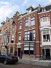 Pand in neo-renaissance trant met in de gevel vensters met geblokte ontlastingsbogen. Houten erker met snijwerk en balustrade. Kroonlijst, waarboven dakkapellen