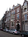 Pand in neo-renaissance trant. Gevel versierd met banden en negblokken. Souterrain. Rechts getoogde ingangspartij. Links houten erker en twee door de kroonlijst heengebroken dakkapellen met trapgevelbekroning