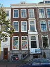 Pand met tweeling gevel met nr. 18 op hardstenen plint met dito stoep, versierde ingangstravee, kroonlijst op gesneden consoles, alles in Lodewijk XIV-stijl