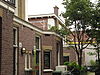 Blok van vier rug-aan-rug gebouwde woningen op vierkante plattegrond, bestaande uit begane grond en verdieping onder een plat dak