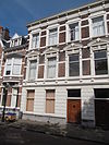 Herenhuis in neo-renaissance trant, eind 19e eeuw, met in pleister gebosseerde parterre en in de verdieping vensters met gebogen frontons. Kroonlijst met consoles