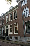 Pand voorzien van gevel met kroonlijst op gesneden consoles, deuromlijsting met pilasters
