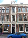 Bouwblok op een rechthoekige plattegrond met winkels en bovenwoningen in eclectische neo-renaissance