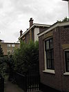 Blok van vier rug-aan-rug gebouwde woningen op vierkante plattegrond, bestaande uit begane grond en verdieping onder een plat dak