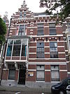 Pand in neo-renaissance trant. Het rechter deel wordt afgesloten door een kroonlijst, waaronder boogfries. Links een rijk gedetailleerde trapgevel in Hollandse renaissancevormen met ontlastingsbogen, waarin vlechtwerk, sierankers en flankerende overhoekse pinakels. Erker op natuurstenen consoles