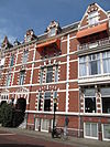 Pand in neo-renaissance trant, versierd met banden en negblokken. Getoogde vensters, in het rechter deel van de gevel driedelig. Links een risaliet met getoogde ingang, bekroond door een fronton. Souterrain; stenen dakkapellen