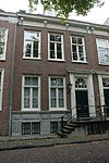 Pand voorzien van gevel met kroonlijst op gesneden consoles, deuromlijsting met pilasters