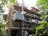 Linkerdeel van een vrijstaand bouwblok bestaande uit twee symmetrische villa's, gebouwd in overgangsarchitectuur, gecombineerd met kenmerken van de 'Stick-style'