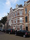 Pand in neo-renaissance trant. Gevelversiering met banden en blokken. Ontlastingsbogen met in de boogtrommels renaissance-versieringen. Dakkapel met rolwerk