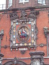 Dordrecht Groothoofdspoort detail -  Dordrecht Maiden sitting in the Garden of Holland, 16th century, by Gillis Huppe. She is surrounded by 16 city shields of cities who rebelled during the eighty years war. From top right, these city shields are the cities of Monnickendam (monk), Enkhuizen (3 fish), Asperen, Heusden, Schiedam, Vlaerdingen, Geertruidenberg, Schoonhoven, Hoorn, Weesp, Leerdam, Naarden, Muiden, Medemblik, and Grootebroek. PAX CIVIVM ET CONCORDIA TVTISSIME VRBEM MVNIVNT CVSTOS ESTO MIHI DEVS IEHOVA  Dordtse maagd op…