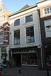 Pand met in natuursteen-imitatie gepleisterde lijstgevel