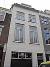 Twee lijstgevels, waaronder nu een winkel; eenvoudige lijstgevel en lijstgevel met kroonlijst, waarin triglyphen en metopen