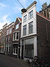 Hoekpand Driehuissteiger. Pand met eenvoudige in rustica-imitatie gepleisterde lijstgevel. Gevel aan de Voorstraatshaven onder rechte lijst