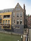 Hoekpand voorzien van halsgevel met bakstenen vleugelstukken, natuurstenen contourbanden, voluten en fronton