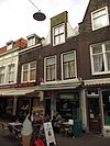Pand met halsgevel met natuurstenen voluten en geprofileerd segmentvormig fronton