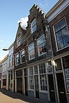 Pand met Dordtse trapgevel met kopjes en sierankers