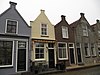 Pand met gepleisterde puntgevel met vlechtingen