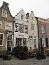 Pand met gepleisterde trapgevel, waarin geprofileerde Gobertangerwaterlijst. Stoep met stoeppalen