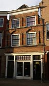Huis met tot lijstgevel gewijzigde trapgevel met dubbele, geblokte pilasters en ontlastingsbogen