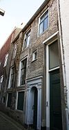 Huis met gewitte lijstgevel met uitgekraagde schoorsteen en empire-schuiframen