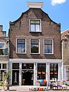 Pand met dubbel gezwenkte topgevel met voluutconsoles afgedekt door lijst