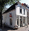 Hoekpand met gepleisterde, ingezwenkte lijstgevel, oorspronkelijk trapgevel