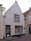 Pand met gepleisterde puntgevel met in het zoldervenster de oorspronkelijke roedenverdeling