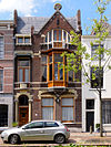 Turfmarkt 104 Gouda -  Turfmarkt 112 Gouda, rijksmonument. Het WOONHUIS gebouwd in ca.1905 in Art nouveau-stijl, van drie traveeÃ«n breed bestaat uit twee lagen onder een met leien gedekte kap met nokrichting parallel aan straat. De gevel heeft links een licht risalerend geveldeel van twee traveeen afgesloten door een steekkap waarvoor tuitgevel met hardstenen afdekking.