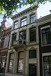 Pand met gepleisterde lijstgevel met balkon en stucversieringen