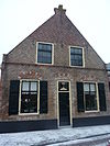 Pand met topgevel en ontlastingsbogen boven de vensters