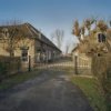 Overzicht voorzijde complex met toegangshek