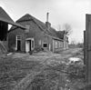 Boerderij onder met riet gedekt wolfdak. Puntgevel met vlechtingen en vensters met luiken. Zijkamer met boven de daklijst opgetrokken puntgevel