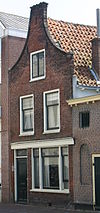 Pand met tuitgevel. Vernieuwde onderpui