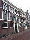 Twee panden. Eerste pand: bakstenen lijstgevel, waarvan de verdiepingen gescheiden worden door hardstenen cordonlijsten. Deuromlijsting met hoofdgestel op consoles. Tweede pand: dezelfde vormgeving, met hardstenen cordonlijsten, houten kroonlijst en deuromlijsting met hoofdgestel op consoles
