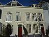 Pand met gepleisterde lijstgevel, deuromlijsting. Stoep met stoeppalen. In de 19e eeuw verfraaid