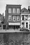 Pand met hoge bakstenen gevel, pilasters in bovenverdieping nauwelijks zichtbaar, rechte kroonlijst
